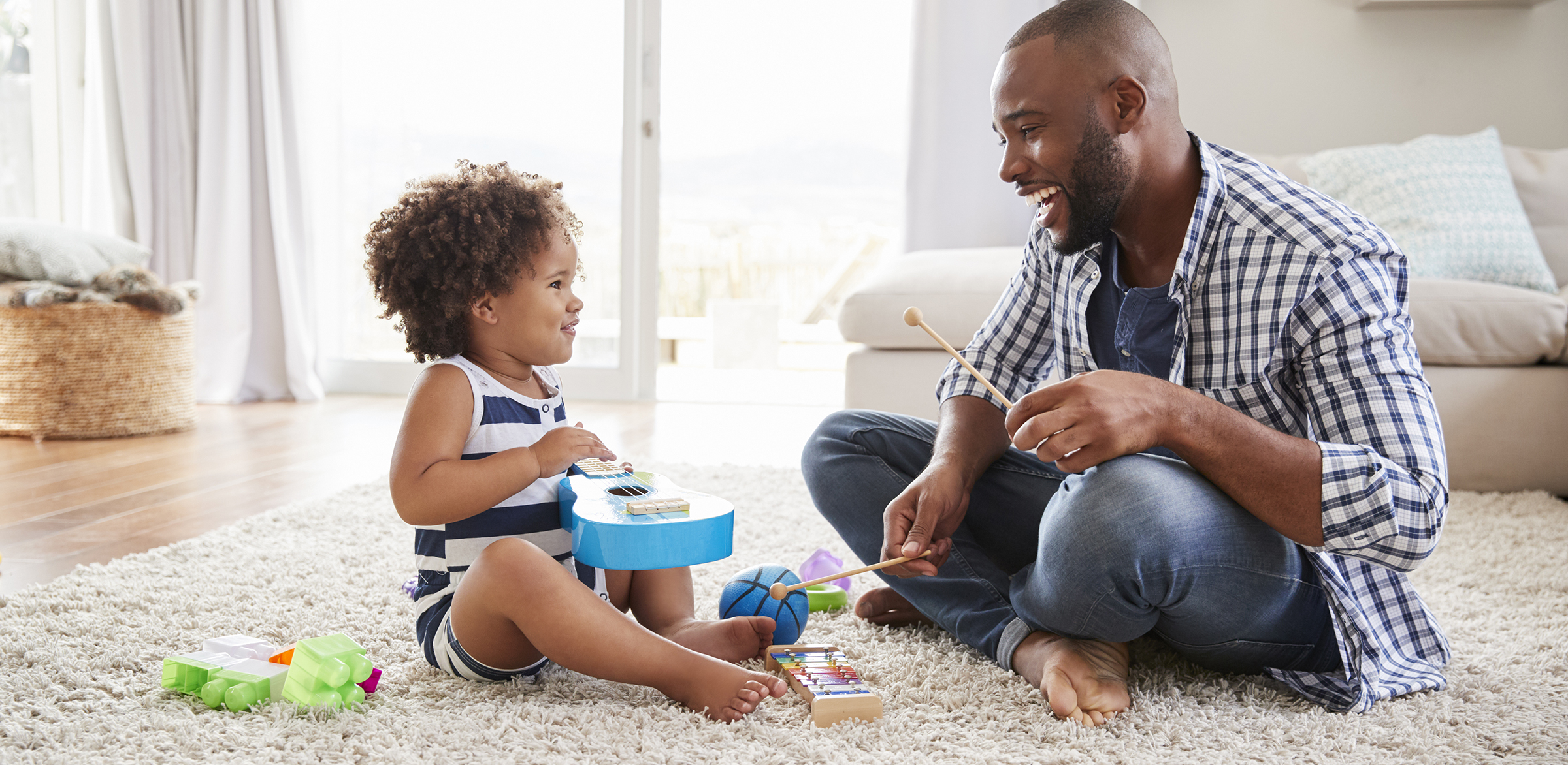 Dad and toddler daughter playing instruments in sitting room Father and Daughter save money in piggy bank